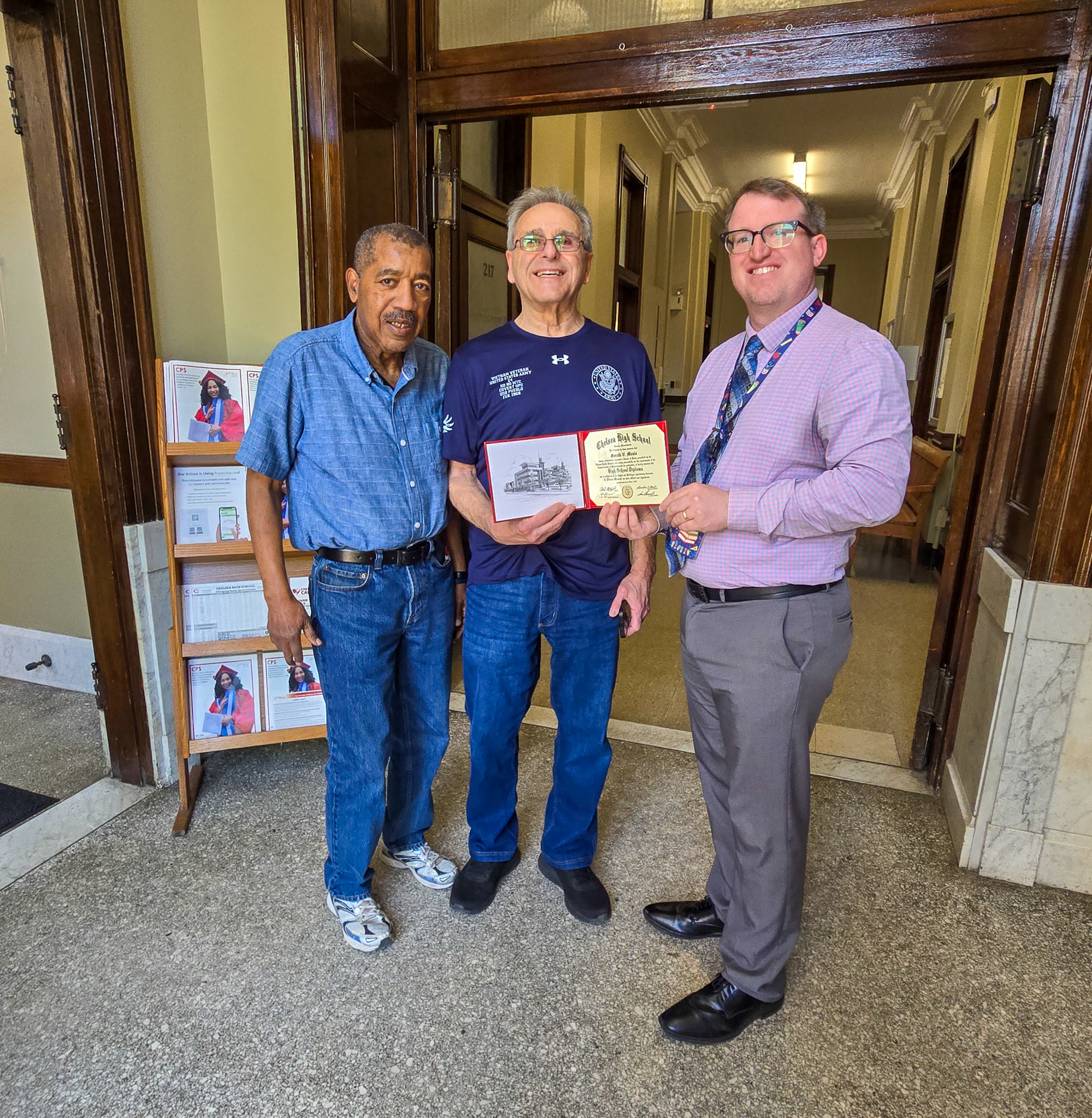 Gerry Meola (middle) received his Chelsea High School diploma at Chelsea City Hall on Thursday, May 1. He was presented the diploma by CPS Communications Director Michael Sullivan (right) and joined by Chelsea City Councilor at Large Leo Robinson 
